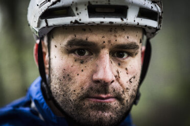 Nahaufnahme eines männlichen Mountainbikers, der mit Schlamm bespritzt wurde - ISF12126