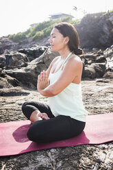 Frau übt Yoga Lotussitz am Strand - ISF12127