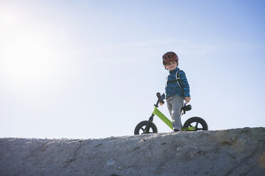 Niedriger Blickwinkel eines Jungen mit Helm, der ein Balance-Bike hält, Draper Cycle Park, Missoula, Montana, USA - ISF12135