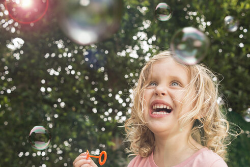 Young girl blowing bubbles, outdoors - ISF12184