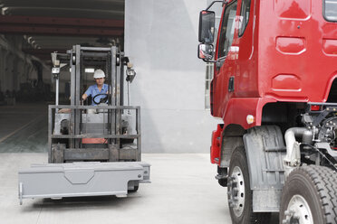 Männlicher Fabrikarbeiter fährt Gabelstapler in einer Kranfabrik, China - ISF12210