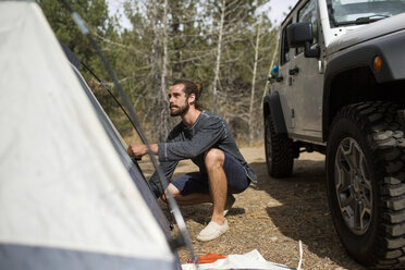 Junger Mann baut ein Zelt im Wald auf, Lake Tahoe, Nevada, USA - ISF12236
