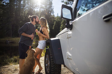 Romantic young couple kissing on riverside, Lake Tahoe, Nevada, USA - ISF12249