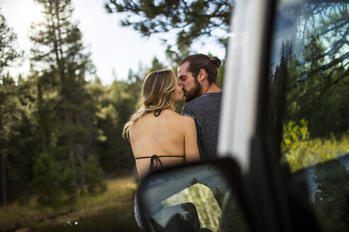 Rückansicht eines romantischen jungen Paares, das sich am Flussufer küsst, Lake Tahoe, Nevada, USA - ISF12251