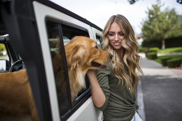 Junge Frau streichelt ihren Hund am Jeepfenster - ISF12260