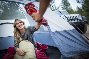Junges Paar teilt sich beim Zelten Snacks, Lake Tahoe, Nevada, USA - ISF12275