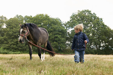 Kleiner Junge führt Pony im Feld - ISF12286