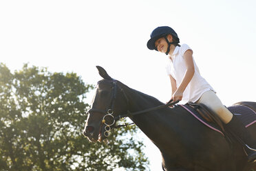 Niedriger Blickwinkel von Mädchen reiten Pferd auf dem Lande - ISF12292