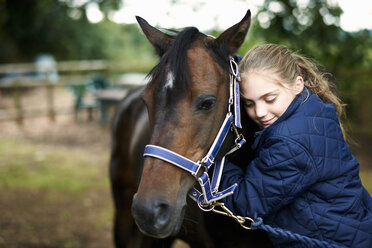 Reiterin, die ihr Pferd umarmt - ISF12302