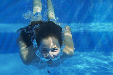 Unterwasser-Porträt von Mädchen unter Wasser schwimmen im Schwimmbad - ISF12344