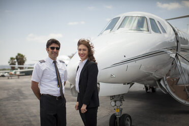 Porträt einer Geschäftsfrau und eines Piloten eines Privatjets auf einem Flughafen - ISF12397