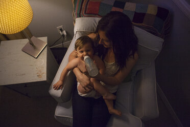 Hohe Winkel Ansicht der Mutter im Sessel Fütterung Baby Junge aus Babyflasche - ISF12483