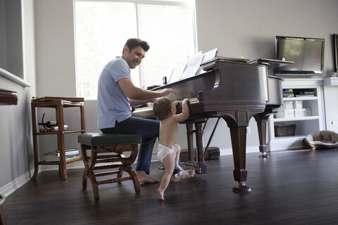 Vater und kleiner Junge spielen auf dem Klavier, lizenzfreies Stockfoto