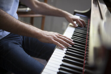 Cropped view of mature man sitting playing piano - ISF12489