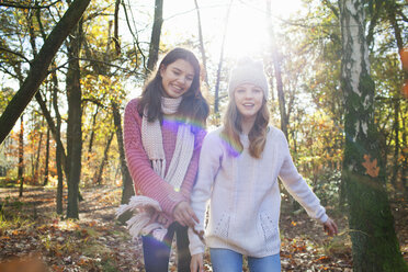 Teenage girls in forest looking at camera smiling - ISF12563