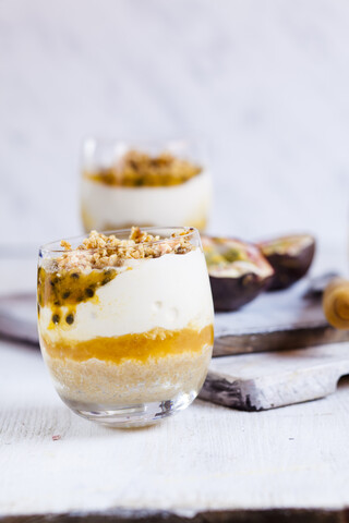 Ungebackener Käsekuchen im Glas mit Passionsfrucht und Nusskrokant, lizenzfreies Stockfoto