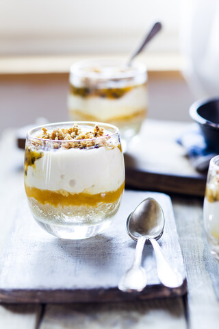 Unbaked cheesecake in a glass with passion fruit and nut brittle stock photo