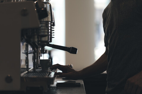 Barista bereitet Kaffee in einer Kaffeebar zu, Teilansicht, lizenzfreies Stockfoto