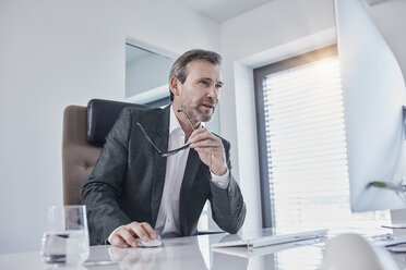 Businessman working at desk in office - RORF01278