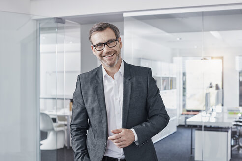 Portrait of happy businessman in office - RORF01297