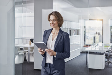 Businesswoman using tablet in office - RORF01306