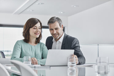 Businessman and businesswoman having a meeting in office with laptop - RORF01338