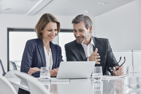 Businessman and businesswoman having a meeting in office with laptop - RORF01352