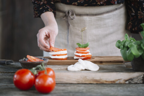 Frauenhände bei der Zubereitung von Caprese-Salat, lizenzfreies Stockfoto