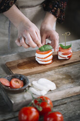 Woman's hands preparing Caprese Salad, partial view - ALBF00528