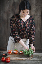 Frau bei der Zubereitung eines Caprese-Salats - ALBF00532