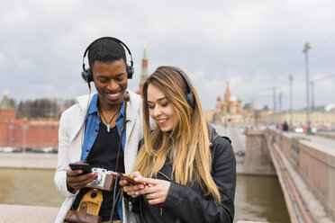 Russland, Moskau, multirassische beste Freunde hören Musik mit Kopfhörern - WPEF00431