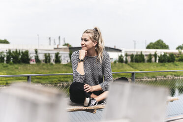Young businesswoman sitting outdoors, taking a break - UUF14203