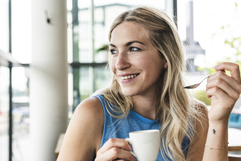 Junge Frau in einem Café trinkt Kaffee - UUF14252