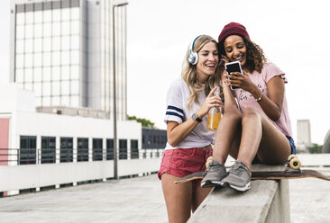 Best friends with skateboard, having fun together, listening music - UUF14258