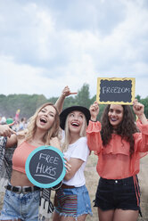 Happy women at the music festival with signs, free hugs, freedom - ABIF00607
