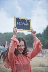 Woman holding sign at music festival, freedom - ABIF00609