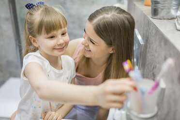 Mother and daughter brushing teeth in bathroom - AWF00065