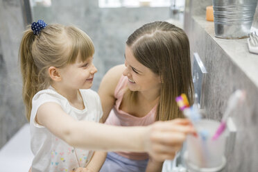 Mother and daughter brushing teeth in bathroom - AWF00066