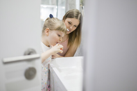 Mutter und Tochter beim Zähneputzen im Badezimmer, lizenzfreies Stockfoto