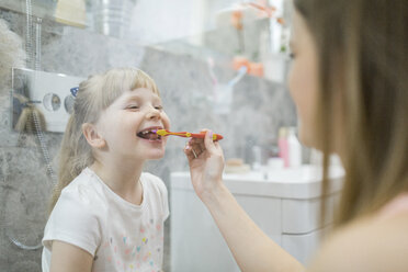 Mother brushing teeth of her daughter in bathroom - AWF00071
