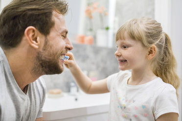 Mother and daughter brushing teeth in bathroom - AWF00086