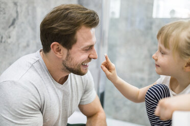 Father and daughter using face cream in bathroom - AWF00092