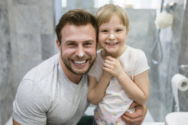 Father and daughter using face cream in bathroom - AWF00093