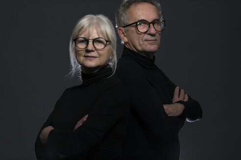 Portrait of senior couple wearing glasses in front of dark background - AWF00098