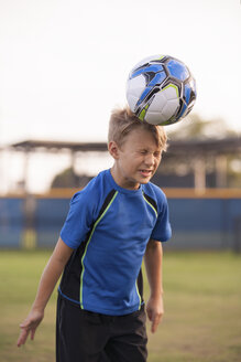 Junge mit geschlossenen Augen beim Fußballspielen auf dem Übungsplatz - ISF12686