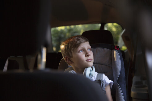 Junge auf dem Rücksitz eines Autos, der durch das Fenster hinausschaut - ISF12688