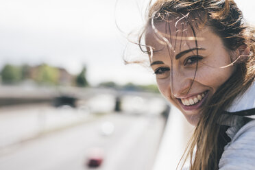 Portrait of smiling sportive young woman outdoors - KNSF04033