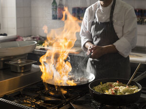 Koch beim Kochen in der Küche mit brennender Pfanne - CVF00846