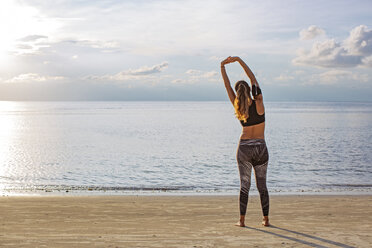 Thailand, Koh Phangan, Sportive woman doing workout on the beach - MOMF00460