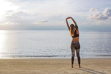 Thailand, Koh Phangan, Sportliche Frau beim Workout am Strand - MOMF00460